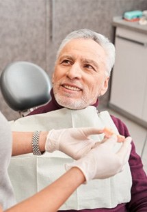 Dentist pointing to a dental implant model