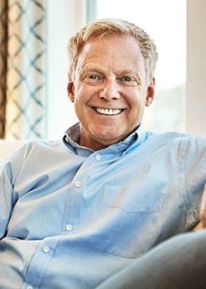 a smiling man sitting on a couch