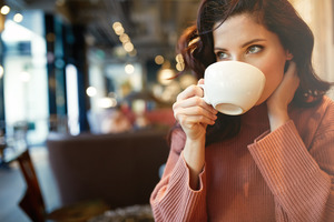 Woman sipping cup of coffee