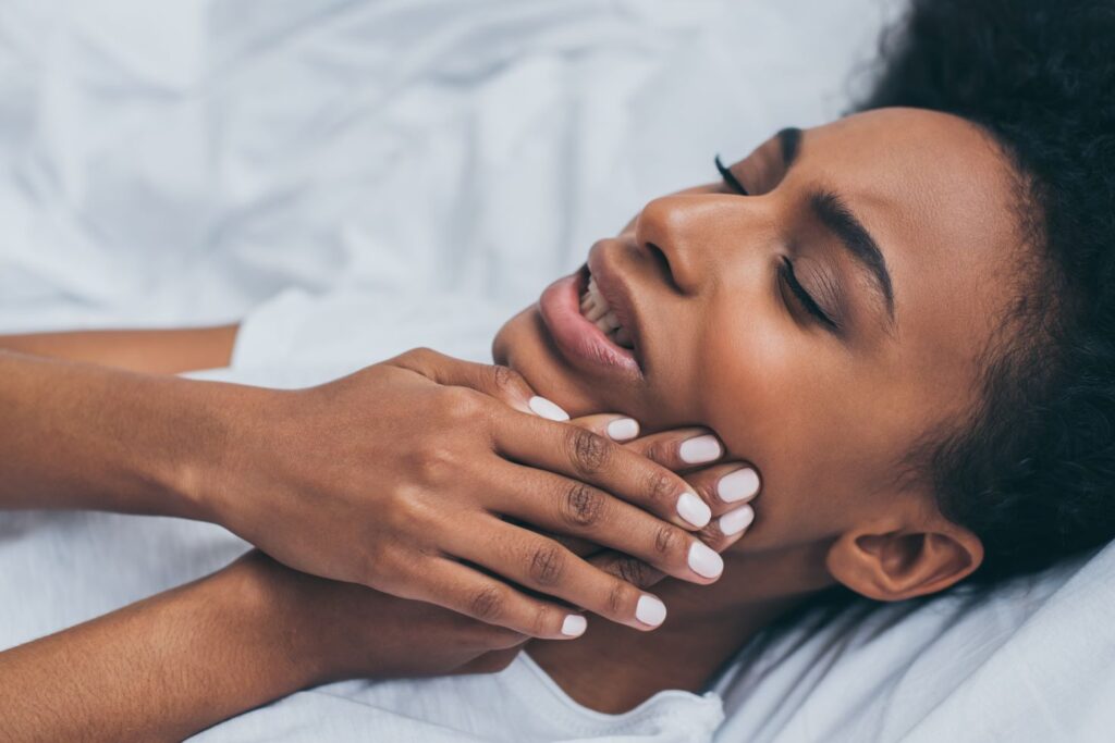 A woman with tooth pain lying in bed